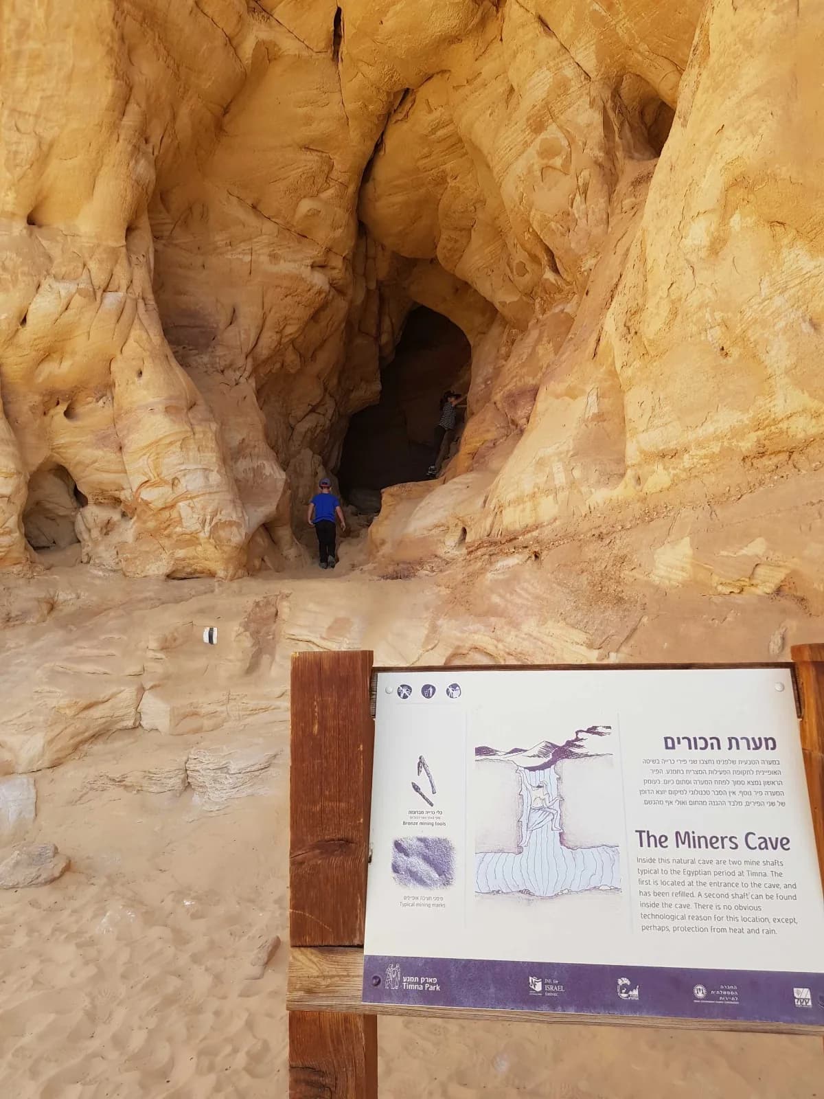 הכניסה למערת הכורים על השביל השחור באזור הקשתות, ולצדה שלט ההסבר של הפארק