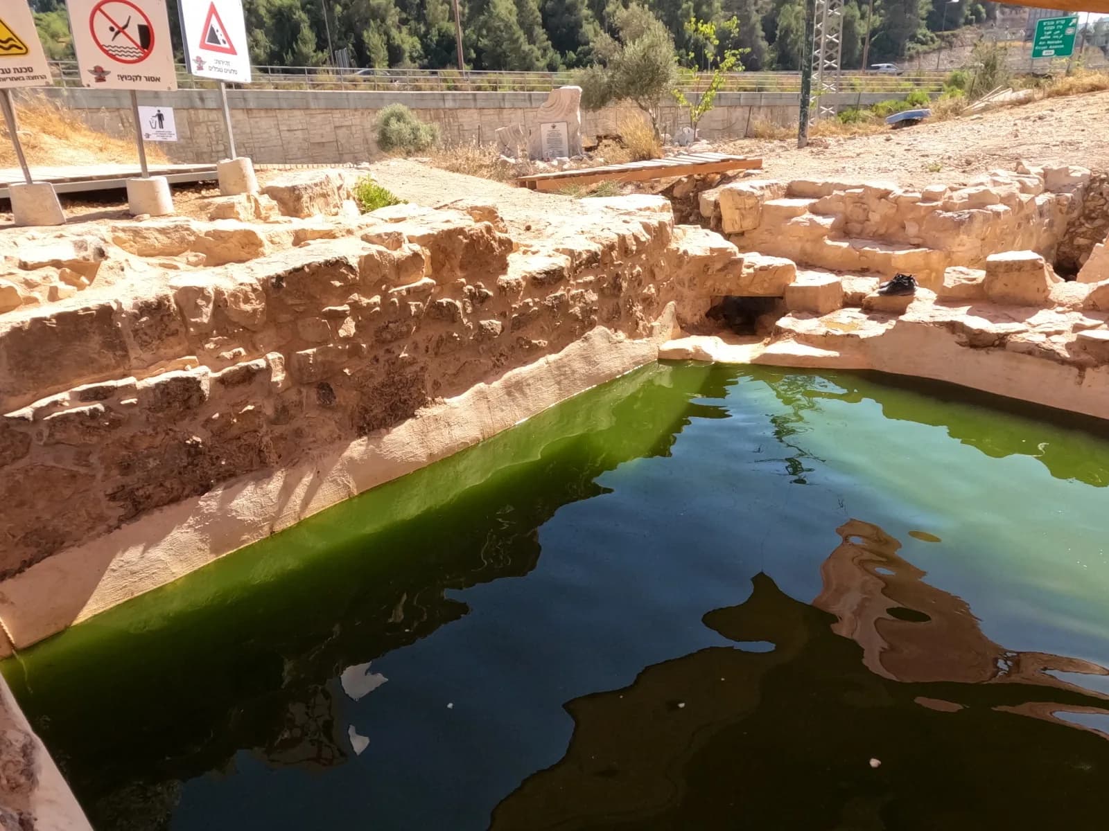 בריכת עין המסייעת והחציבות בסלע שלצידה, ברקע כביש 1