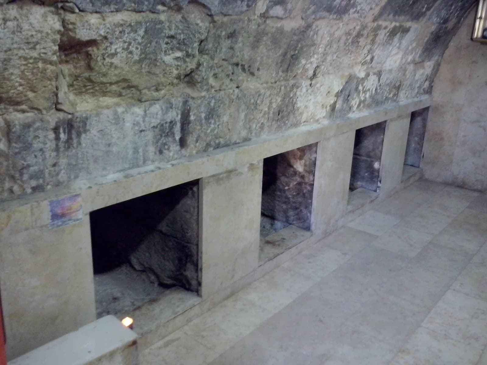 שורת כוכי הקבורה לאורך דופן חדר הקבורה, ומעליהם הסלע החשוף