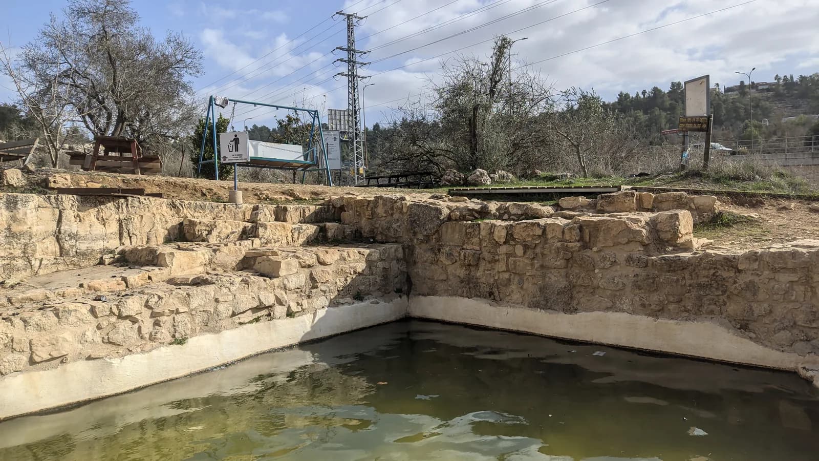 בריכת עין המסייעת בתוך החציבה העתיקה, ומעליה מצוק הסלע