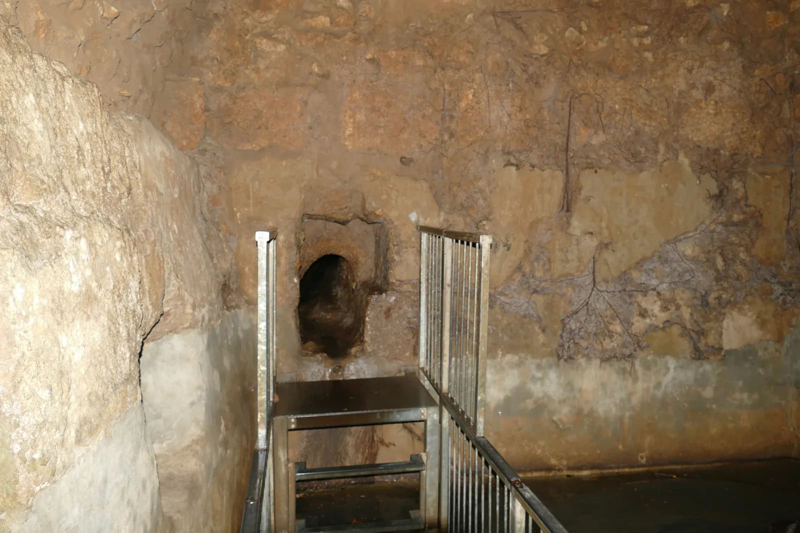 אולם האיגום התת-קרקעי בעין קובי: מדרגות ומעקה היורדים אל הבריכה ופתח הנקבה בקיר