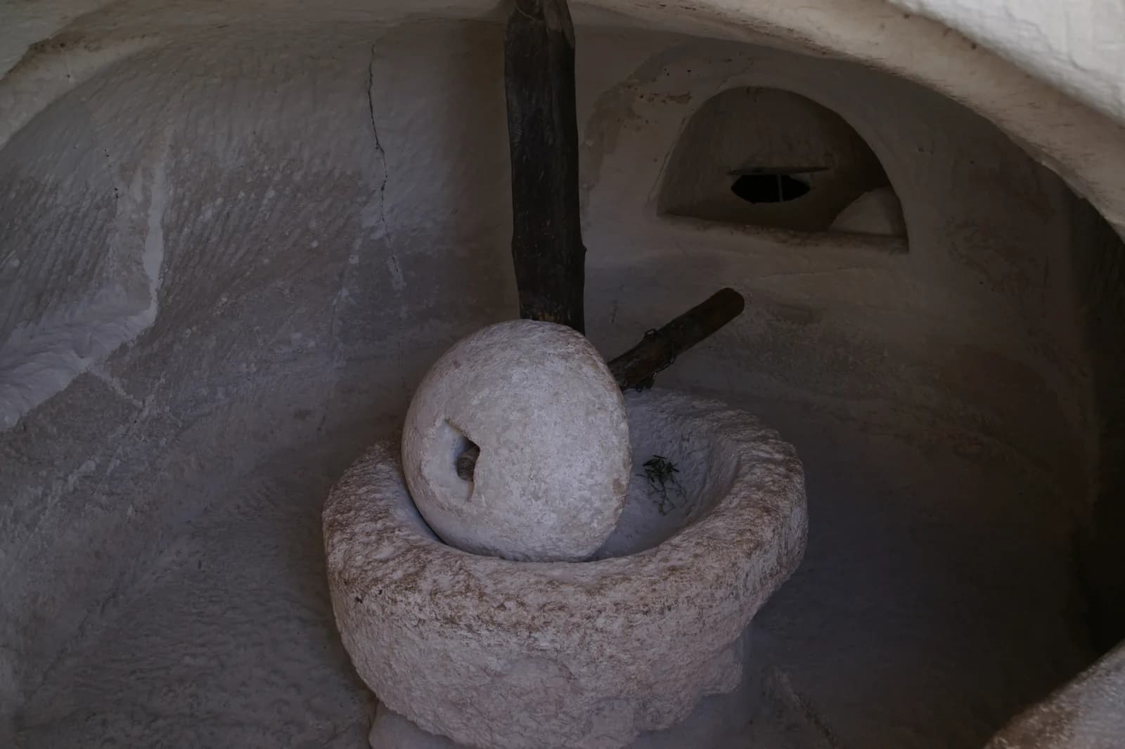 מתקן הריסוק (מפרכה) עם אבן ריסוק בצורת עדשה, בחדר חצוב במערת בית הבד