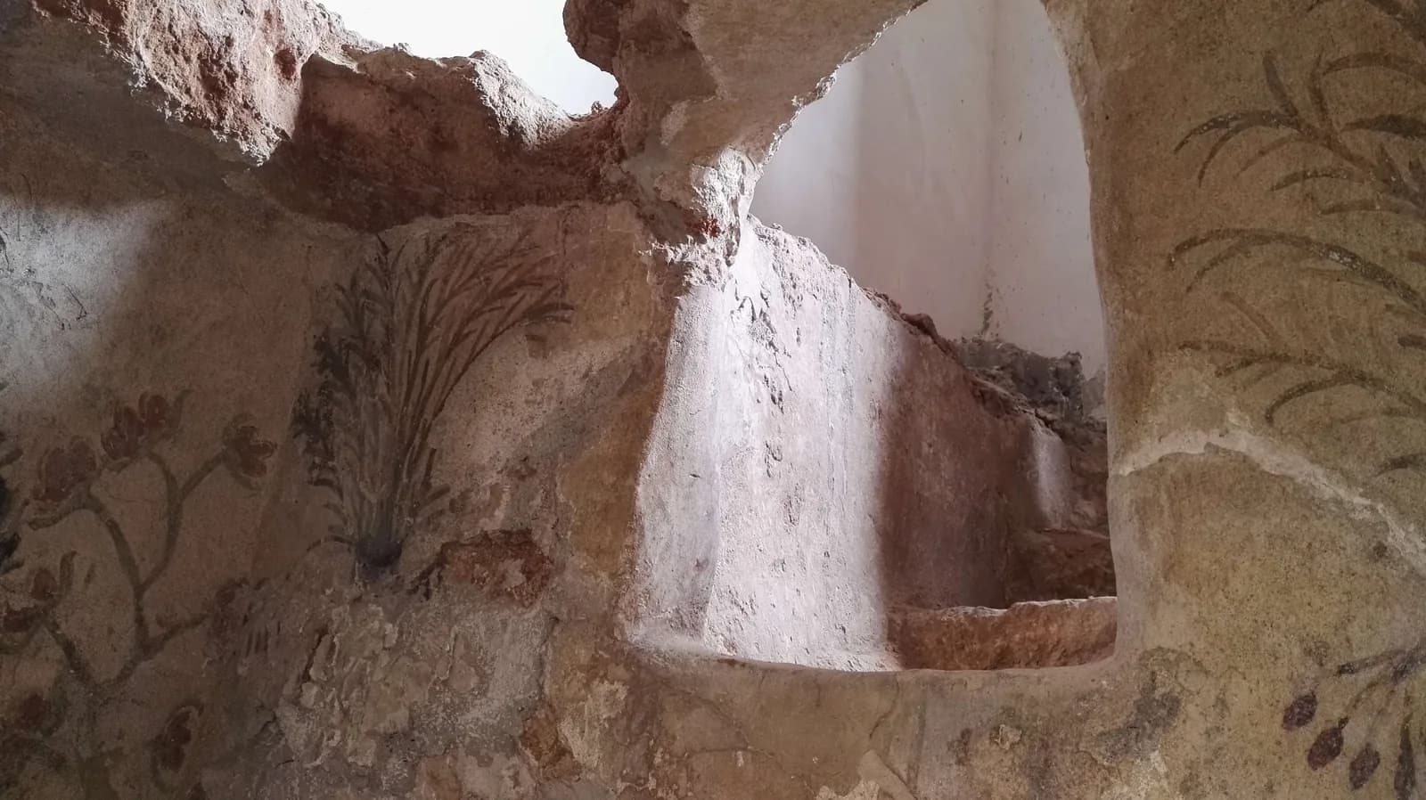 פנים המערה: ציורי עצים וצמחים סביב פתח בקיר