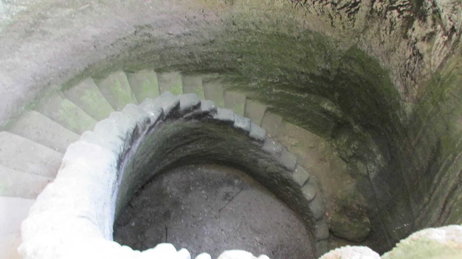 בור המים בקצה מערת בית הבד, עם גרם מדרגות חצוב שמתפתל לאורך הדופן