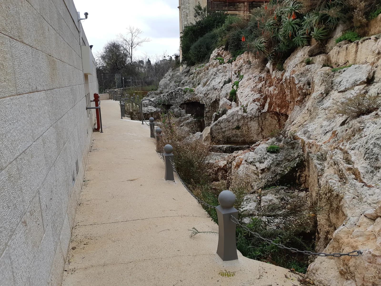השביל הסלול בגן הארכאולוגי לאורך מערות הקבורה בכתף הינום