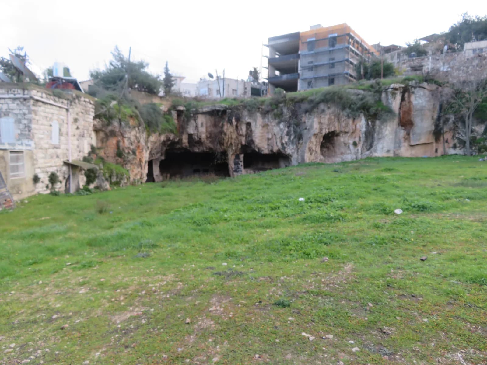 המצוק שבו חצובה מערת הרמב"ן, ובתי שכונת ואדי אל-ג'וז מעליו