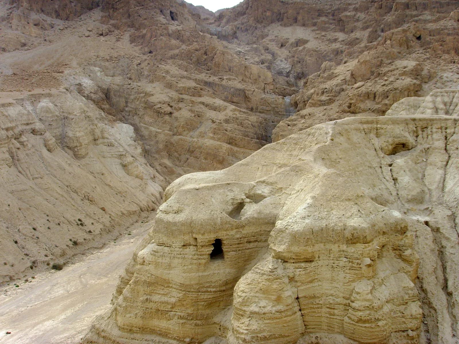 מערה 4 בקומראן, שלוחת החוואר החצובה מעל נחל קומראן, ומאחוריה מצוקי מדבר יהודה