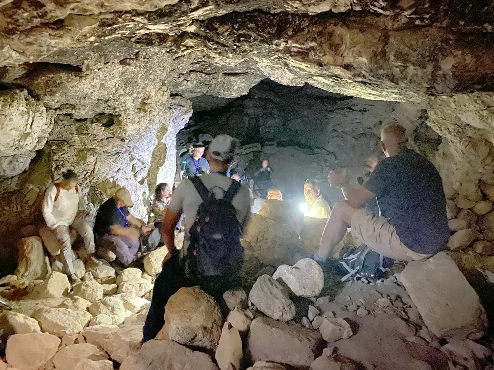 קבוצת מטיילים עם פנסים בתוך אחת ממערות תל עדולם