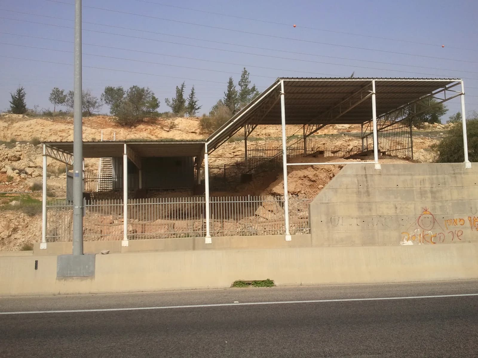 אתר החפירות של מערת קסם, מגודר ומקורה בגג מגן, כפי שהוא נראה מכביש 5