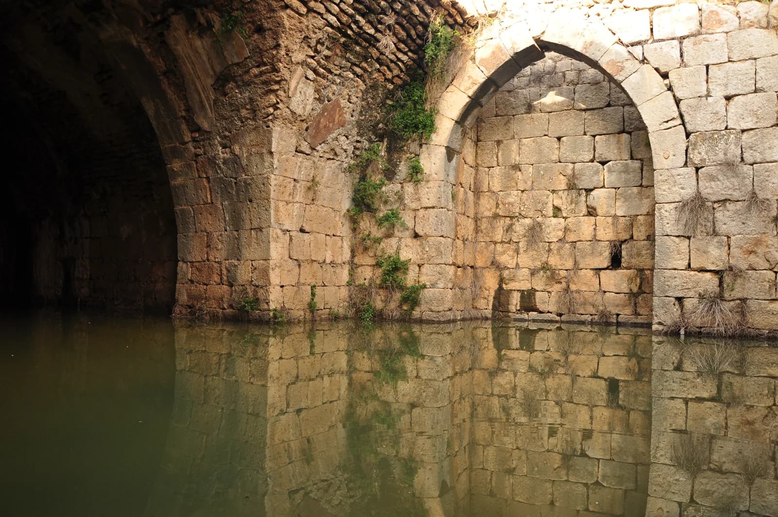 קשתות מאגר המים הגדול במבצר נמרוד משתקפות במי הגשם שבתחתיתו
