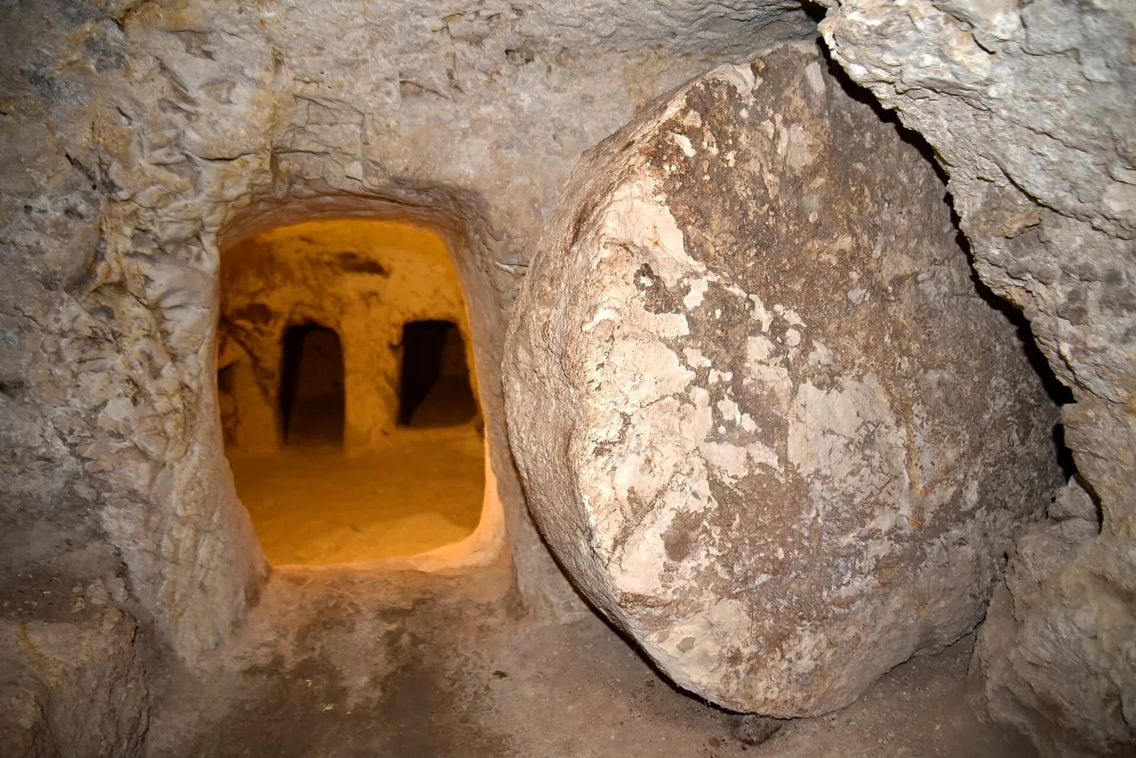פתח קבר הכוכים מימי הבית השני ולצדו אבן הגולל העגולה, במנזר אחיות נצרת
