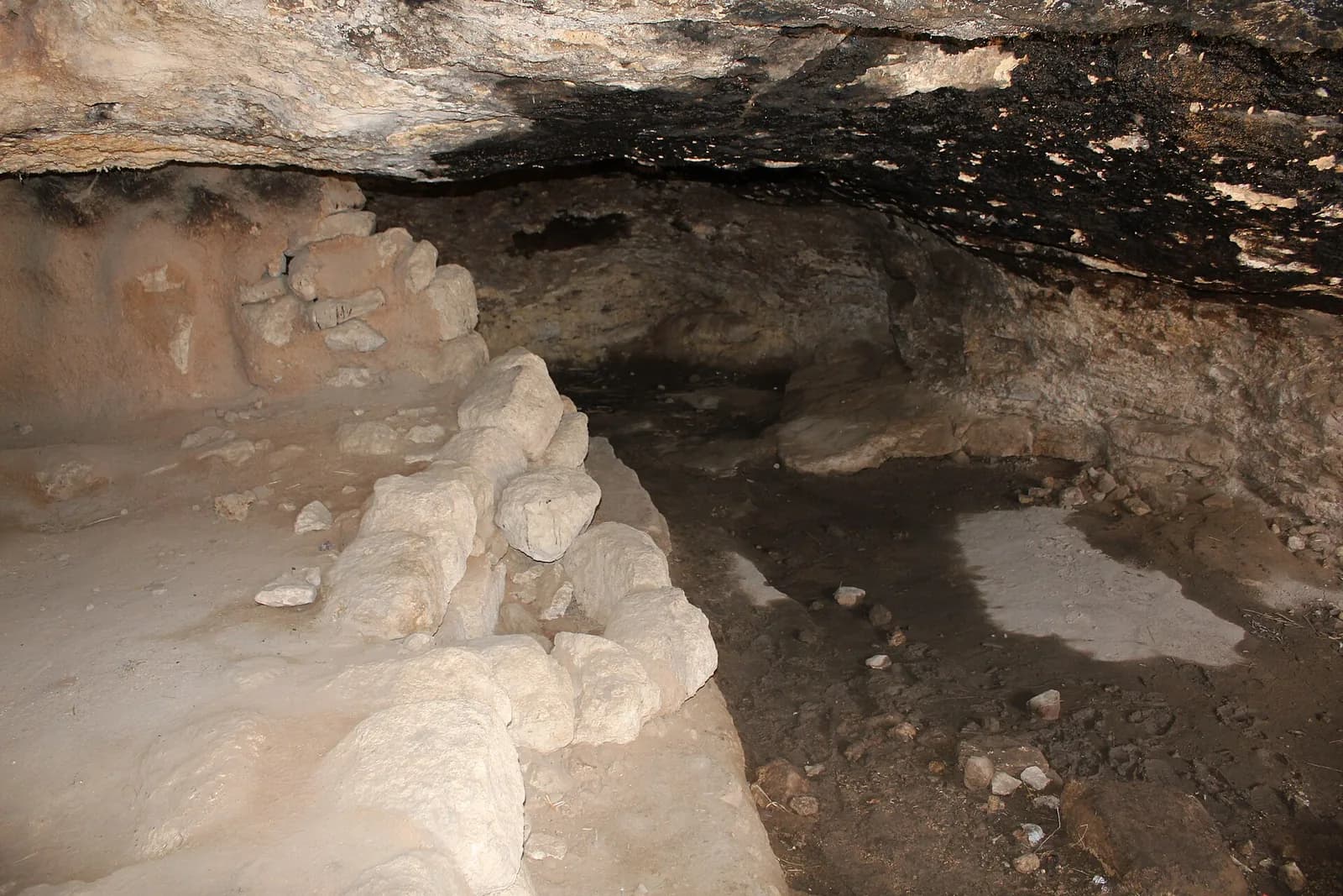 פנים מערת מגורים עתיקה סמוך לבית הכנסת בחורבת ענים, עם קירות אבן פנימיים