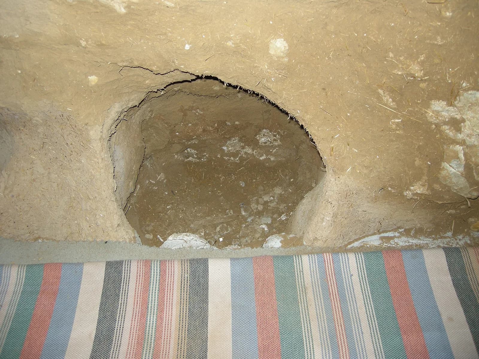 כלי נחושת ישנים מוצגים בגומחה חצובה בקיר המערה בדריג'את