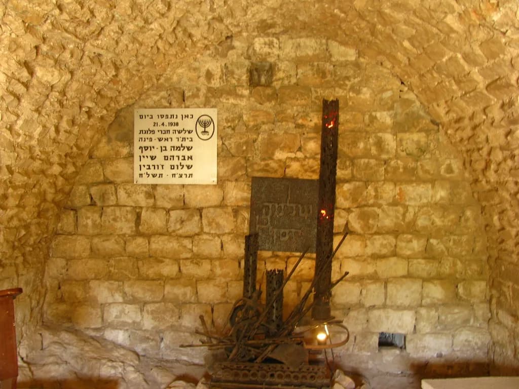 פנים המערה: קמרון אבן, שלט ההנצחה לשלושת חברי בית"ר ופסל מתכת לזכרם
