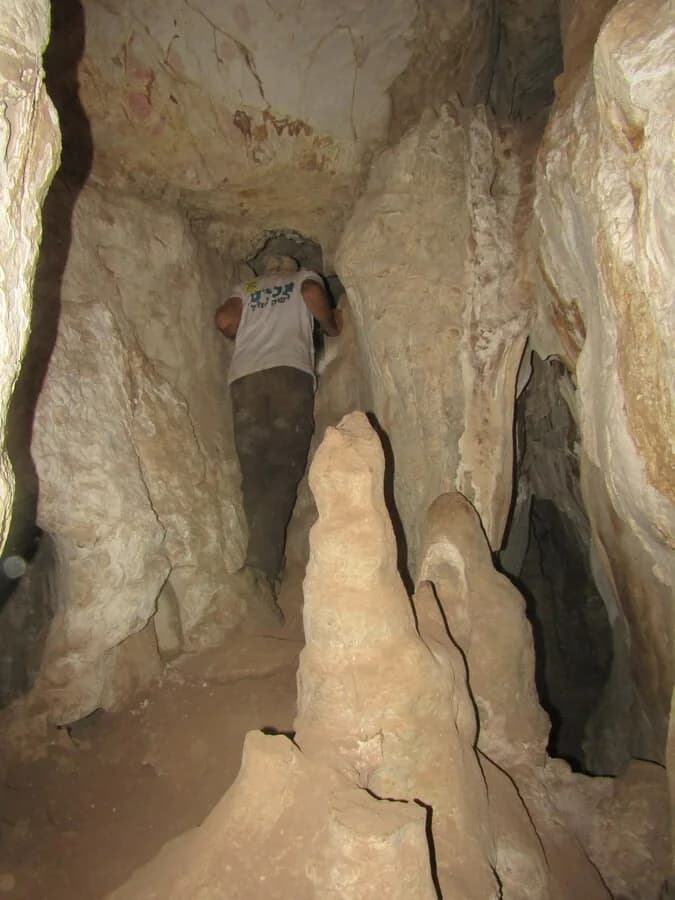 מערן במעבר צר בין זקיפים בתוך מערת הסלע