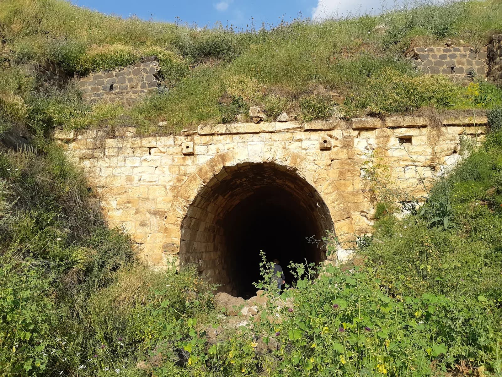 הפתח המערבי של מנהרה 105, חזית אבן מקושתת במדרון עמק הירמוך
