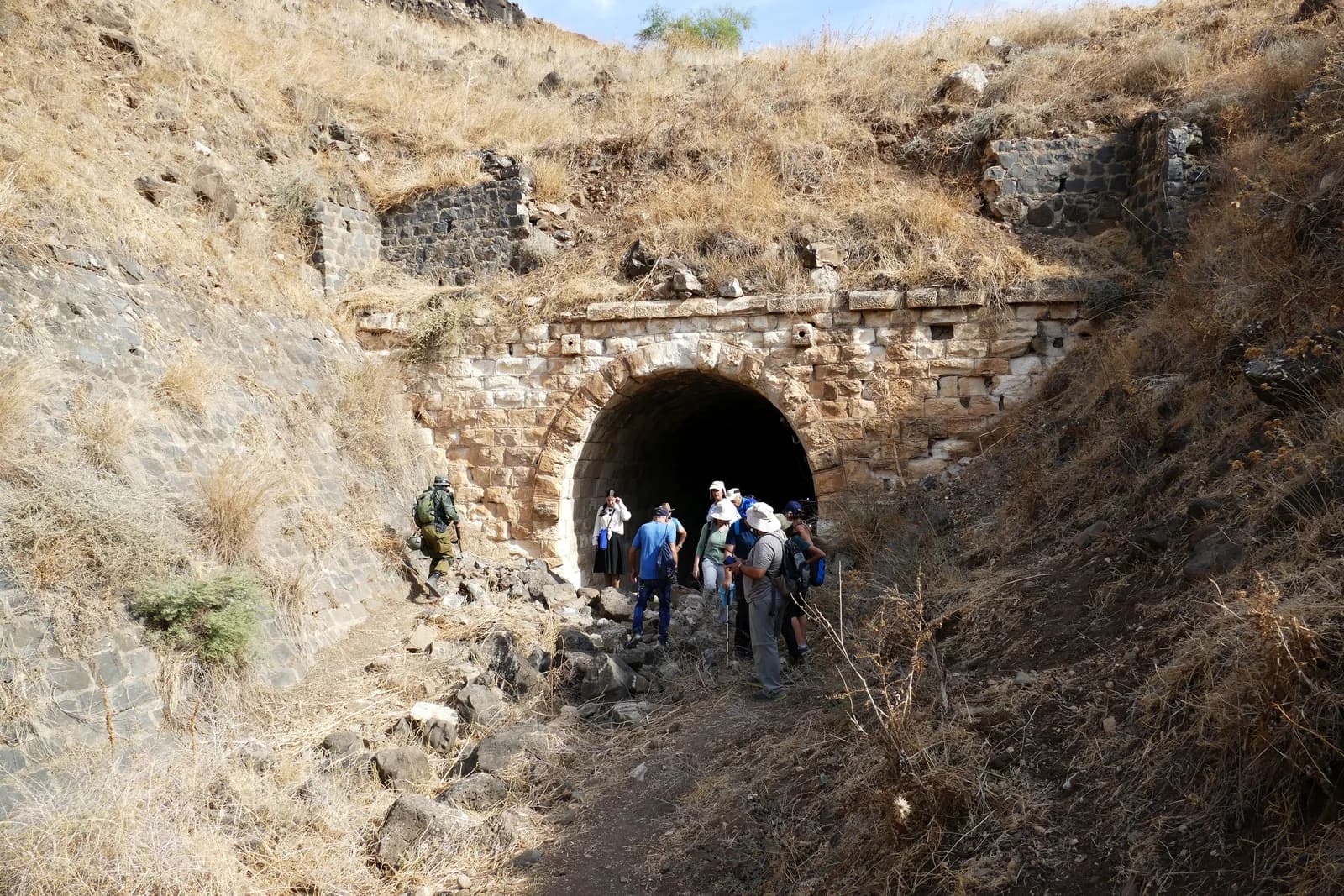 מטיילים בסיור ליד אחד מפתחי המנהרה