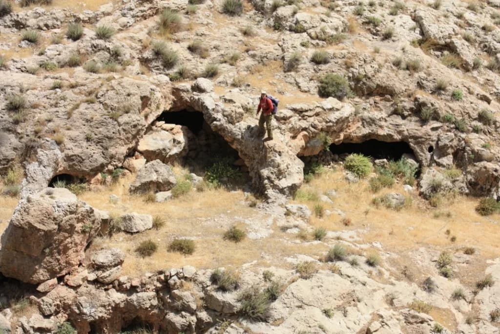 פתחי מערת הנמרים במבט מלמעלה, עם מטייל לקנה מידה