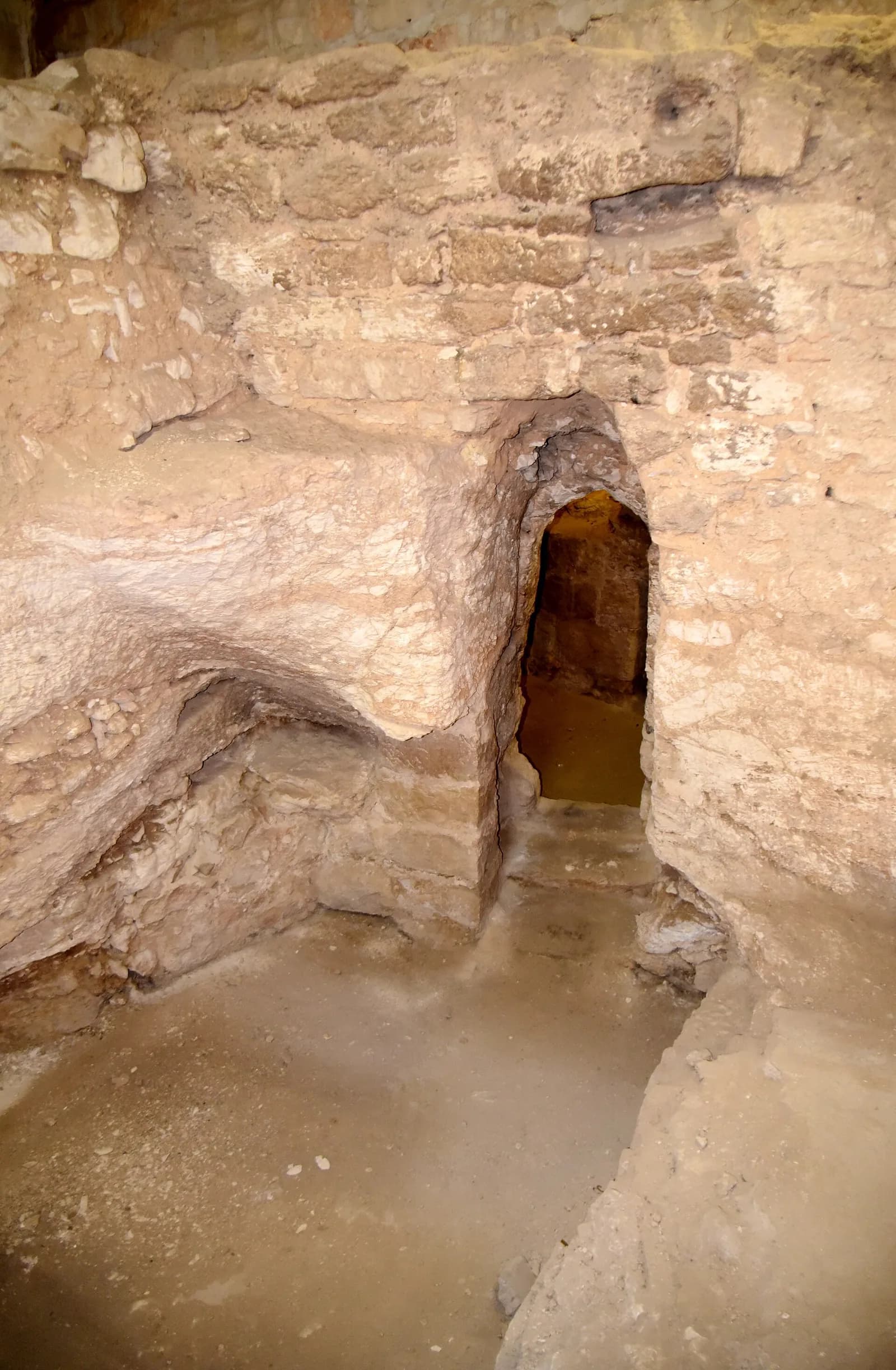 קירות חצובים ובנויים ופתח חצוב בסלע בשרידי המבנה מהמאה ה-1 לספירה מתחת למנזר