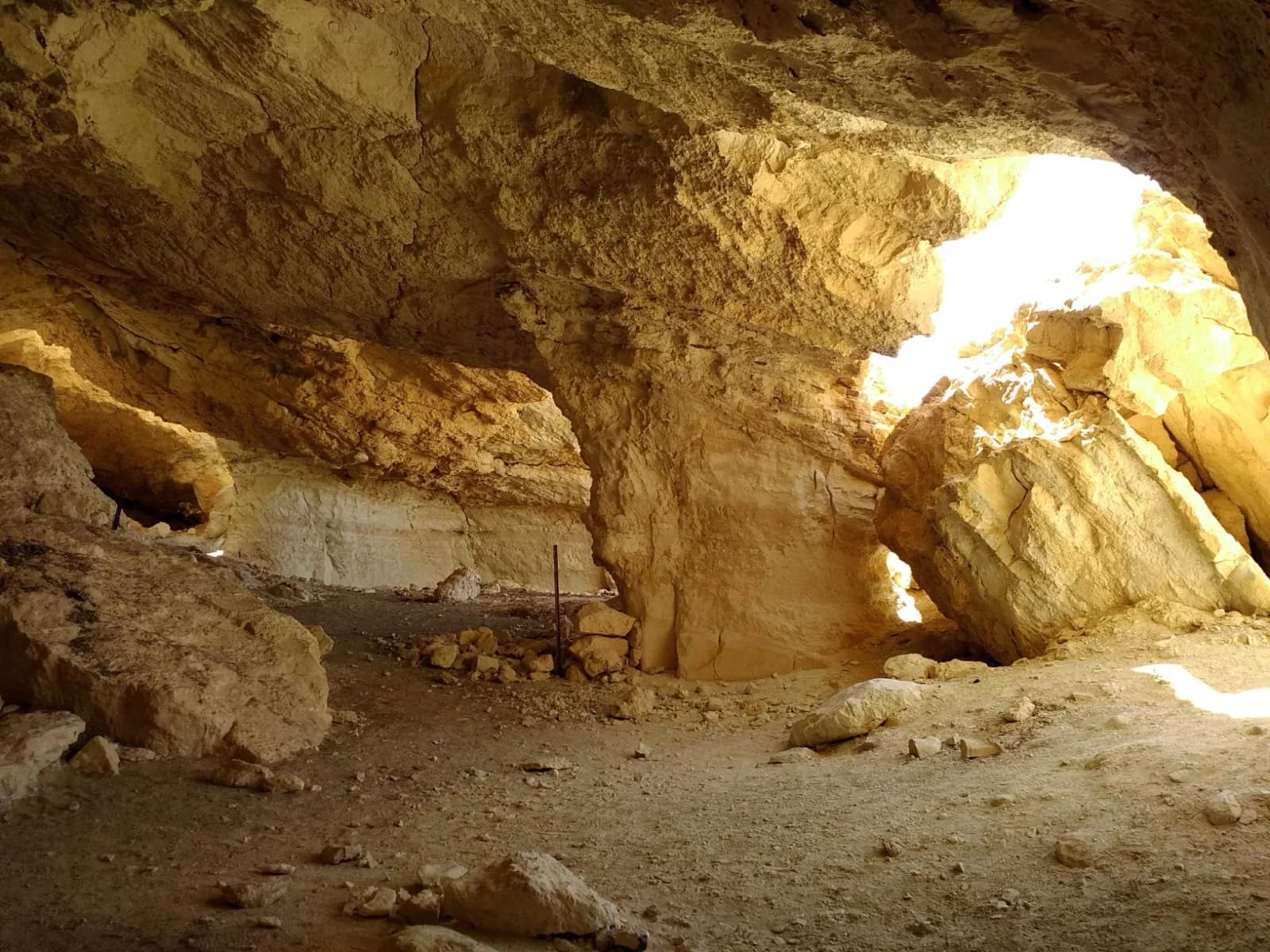 פנים מערת ניצנה: אולם החציבה, עמודי סלע ואור שחודר מפתח בתקרה
