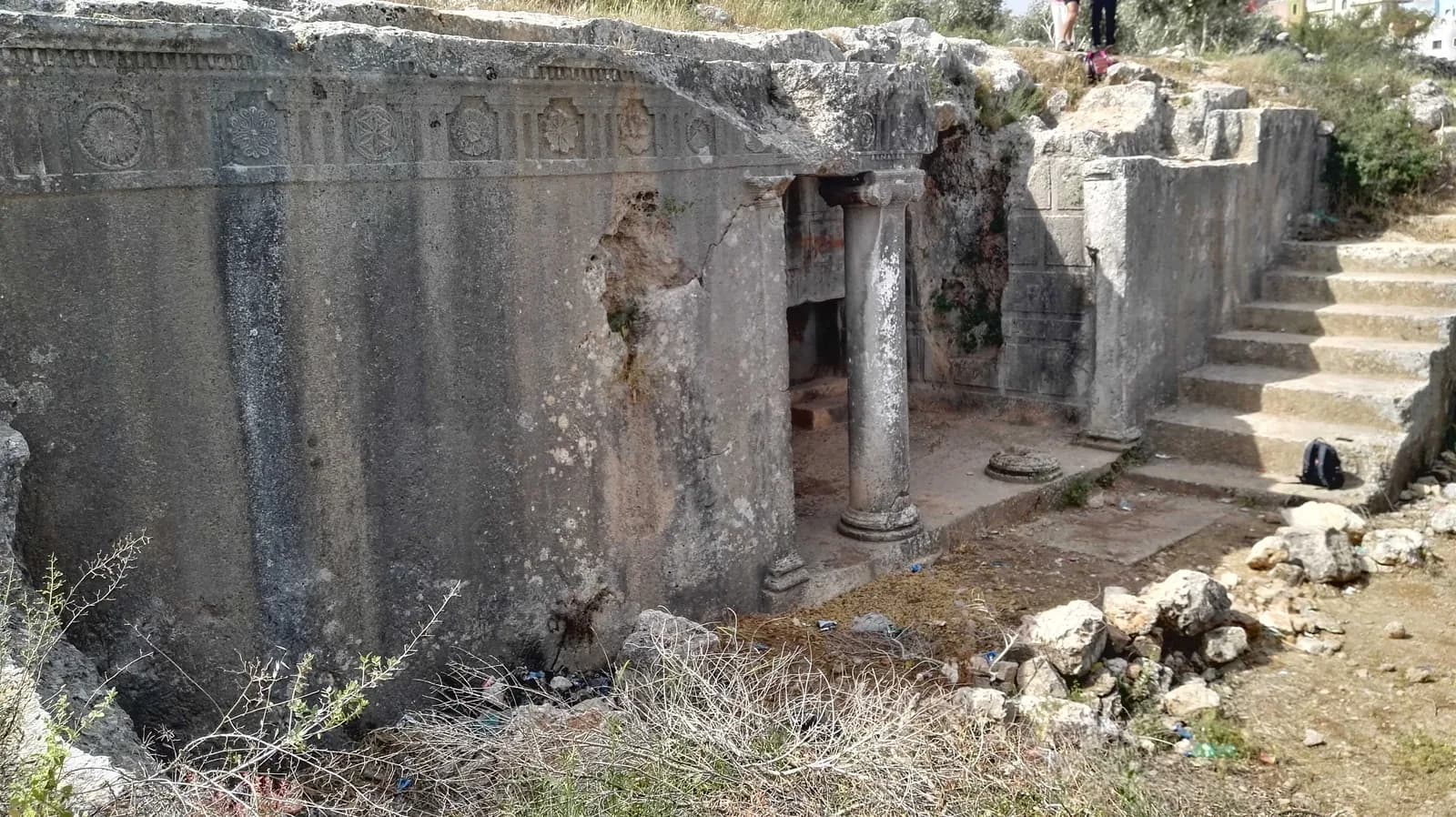 חזית הקבר בדיר א-דרב: האפריז המעוטר, העמוד היוני ששרד והחצר החצובה