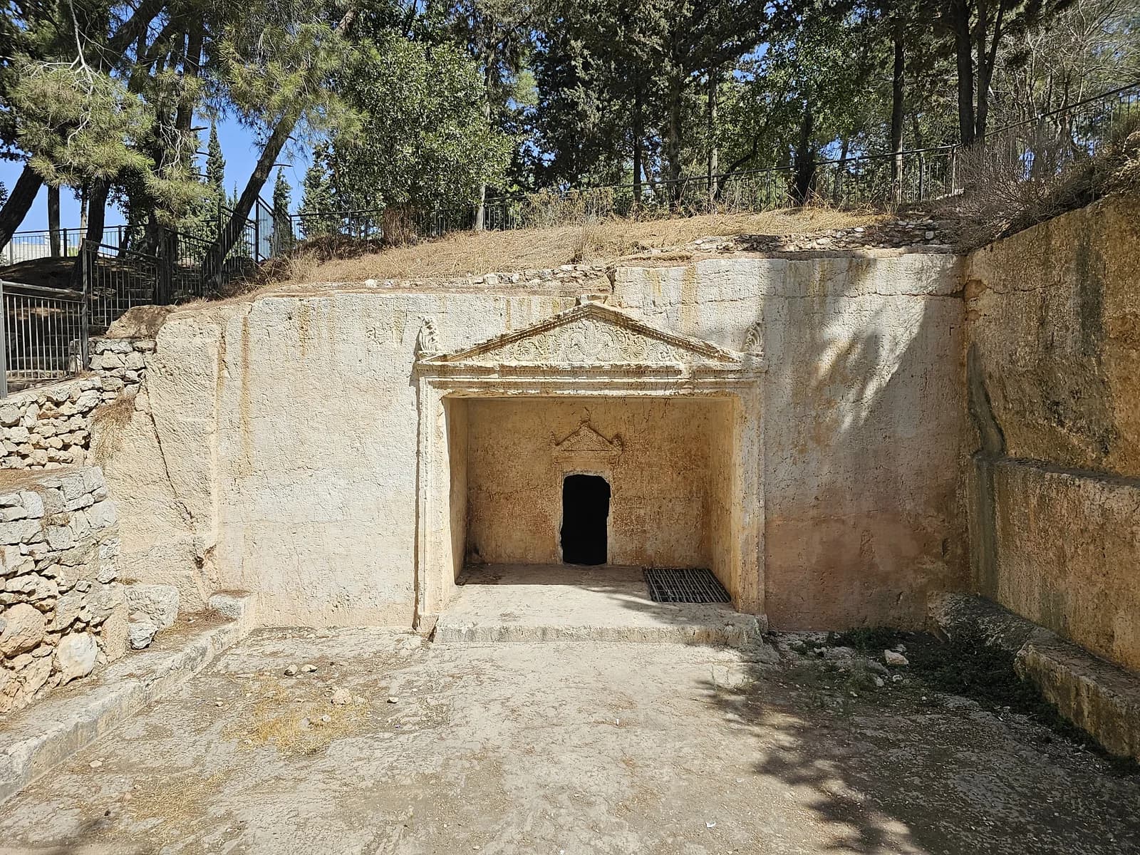 החצר החצובה וחזית מערת הקבורה המרכזית בקברי הסנהדרין, עם הגמלון המעוטר מעל הכניסה