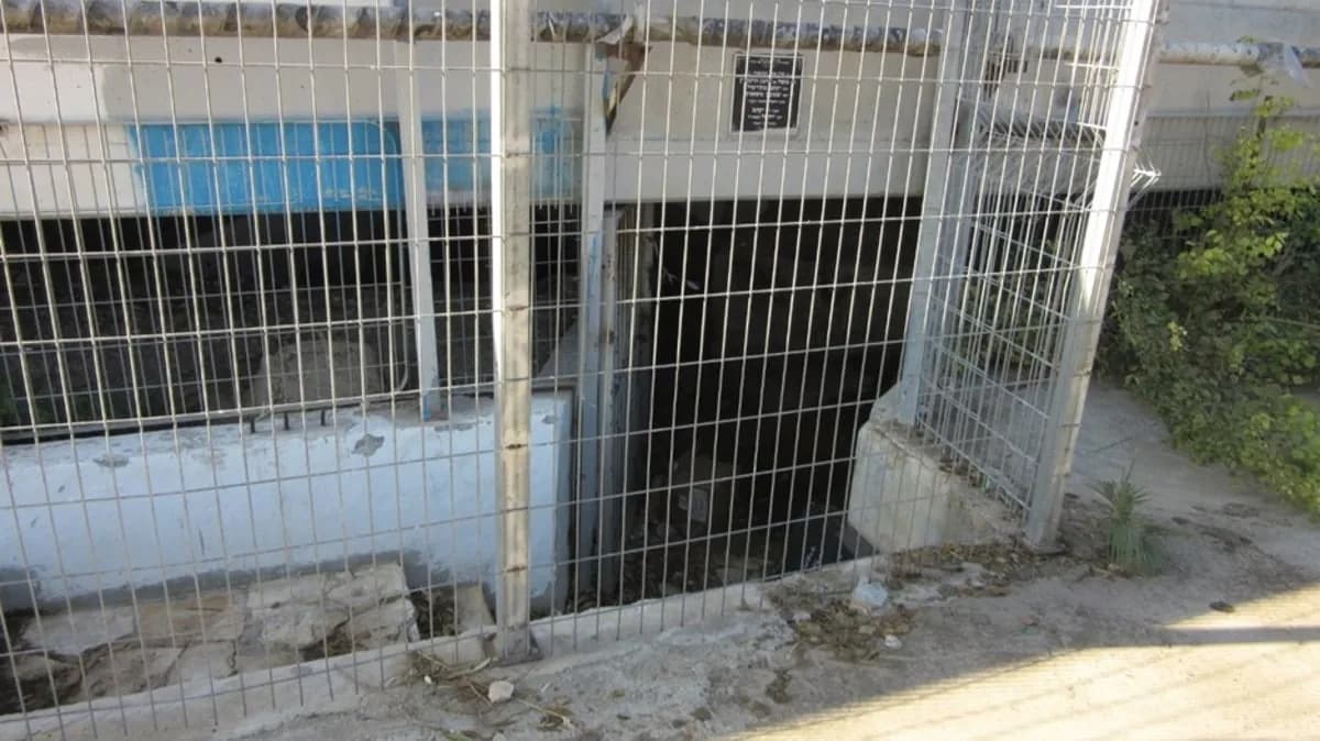 הפתח המגודר והמדרגות היורדות אל המערה מתחת למסילת הרכבת