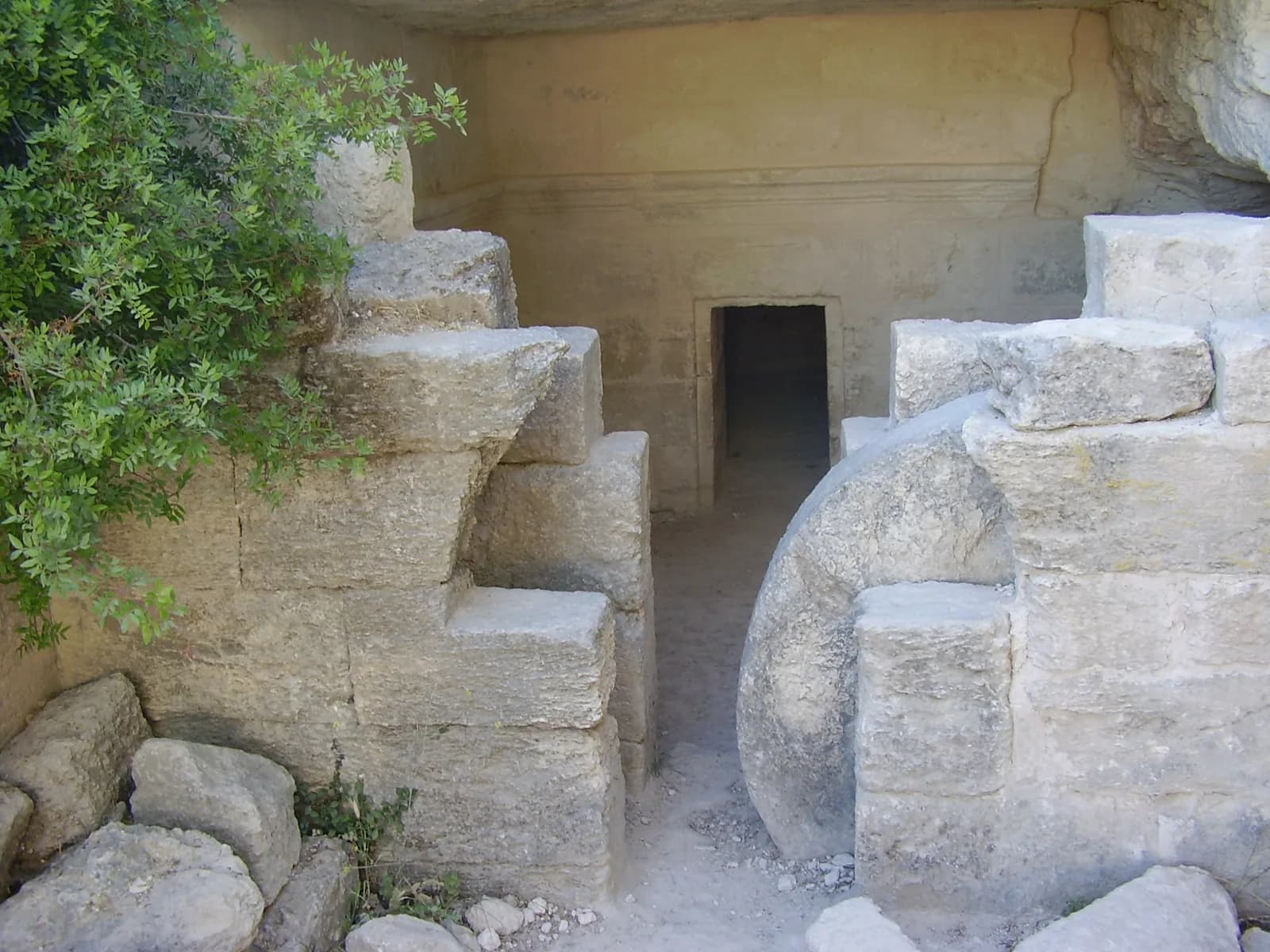 פתח מערת הקבורה בחורבת מדרס, ואבן הגולל העגולה בין הקירות הבנויים