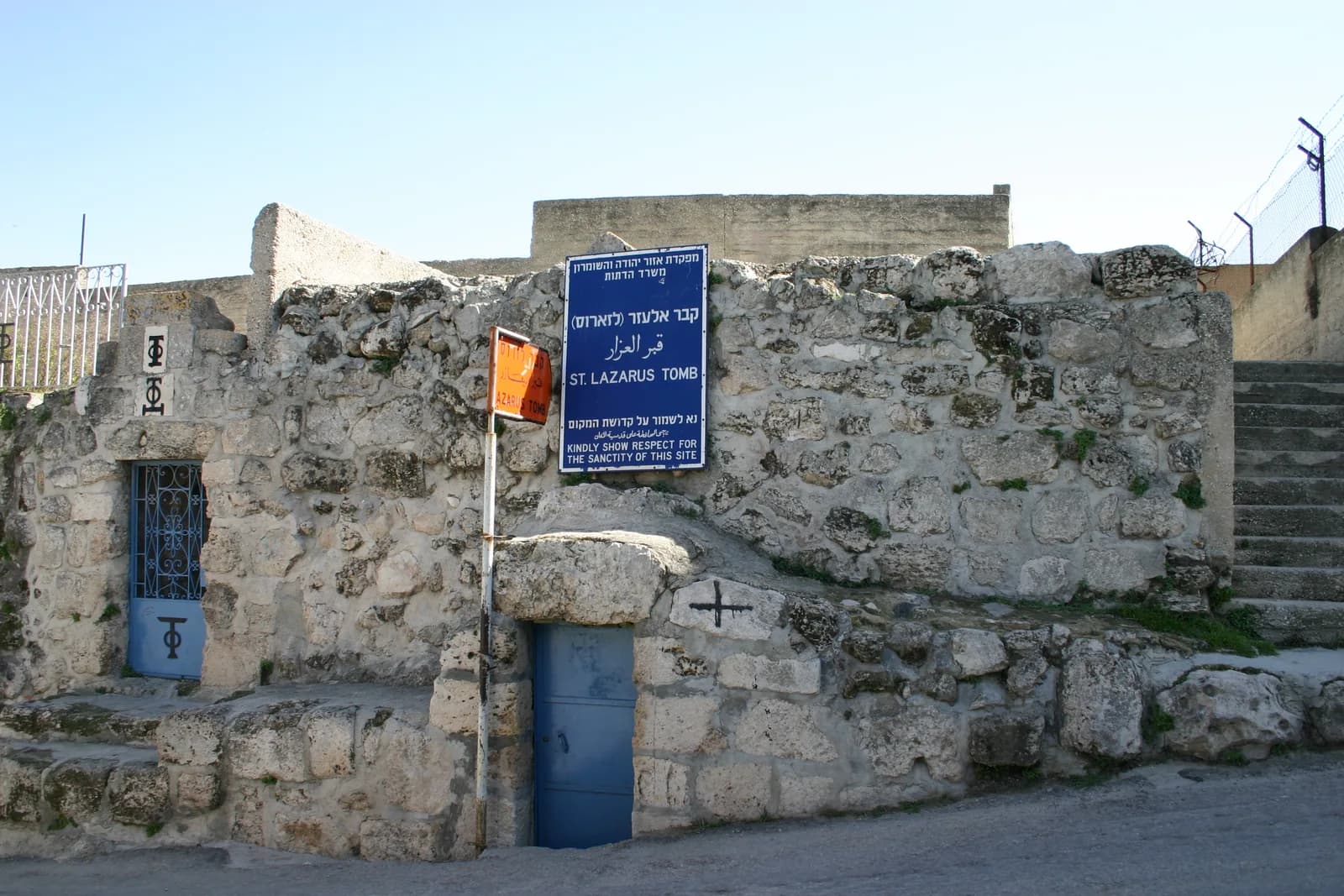 הכניסה לקבר אלעזר מהרחוב באלעיזריה, ולידה שלט האתר