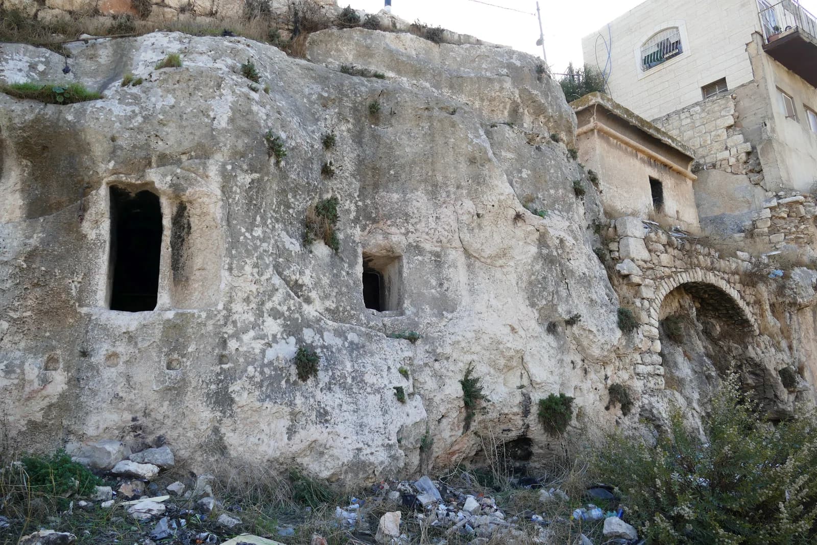 פתחי קברים חצובים בצוק בכפר השילוח, ומימין קבר בת פרעה המונוליתי